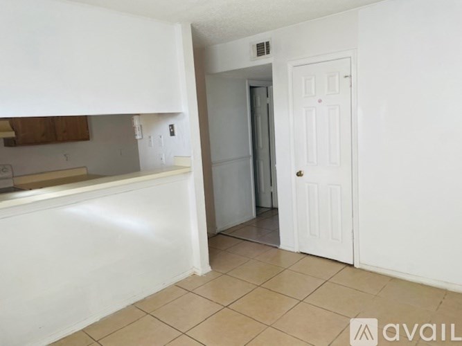 A room with a white door and a tiled floor.