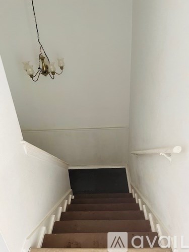 A staircase with a chandelier hanging above it.