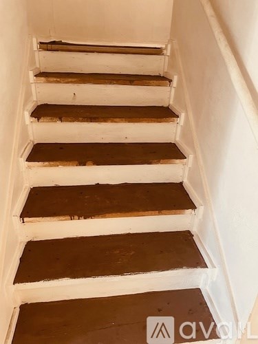 A set of stairs with white risers and brown treads.
