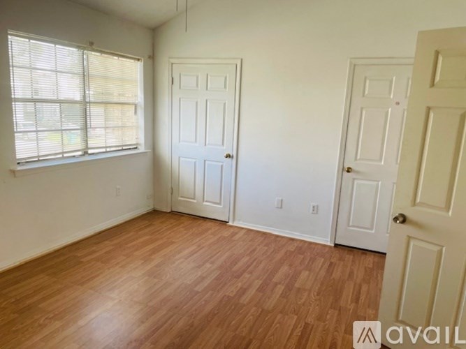 A room with wooden floors and two white doors.