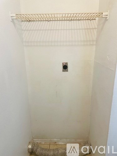 A white wall with a small square hole in the middle.