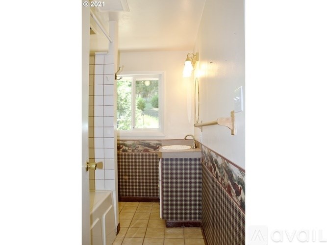 A bathroom with a checkered floor and a window.