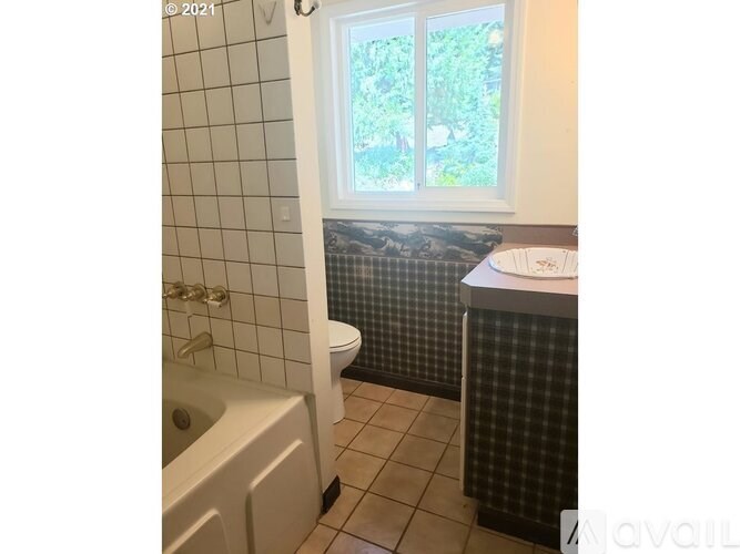 A bathroom with a tub, toilet, and sink.