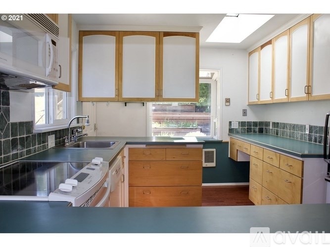 A kitchen with wooden cabinets and a black countertop.