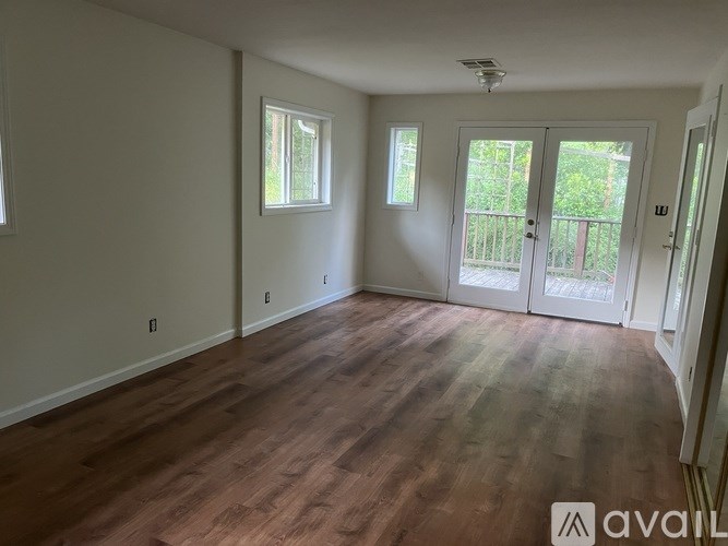 A room with wooden flooring and white walls.