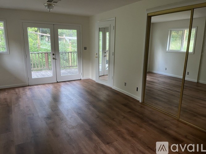 A room with wooden floors and a large mirror on the wall.