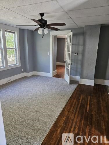 A room with a ceiling fan and a carpeted floor.