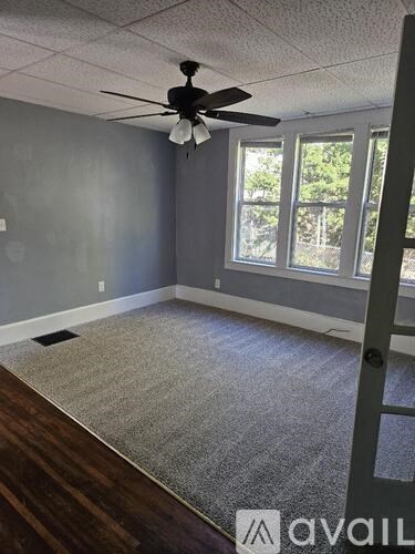 A room with a ceiling fan and a carpeted floor.