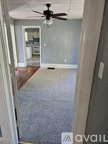 A room with a ceiling fan and a carpeted floor.