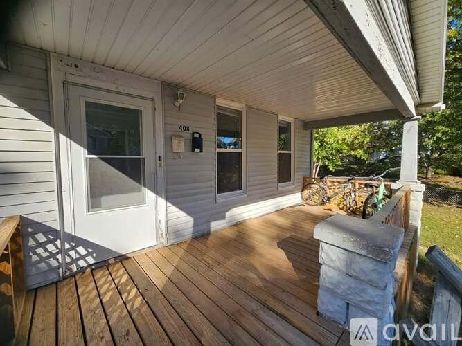 A porch with a white door and a bench.