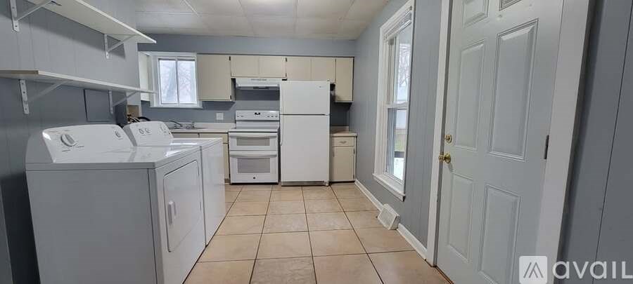 A kitchen with white appliances and cabinets.