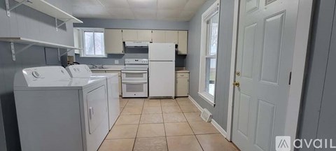 A kitchen with white appliances and cabinets.
