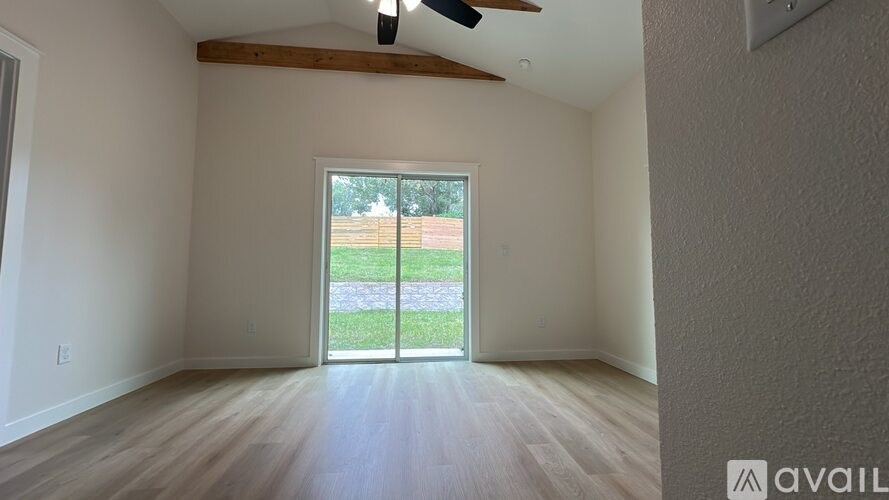 A room with a sliding glass door leading to a backyard.