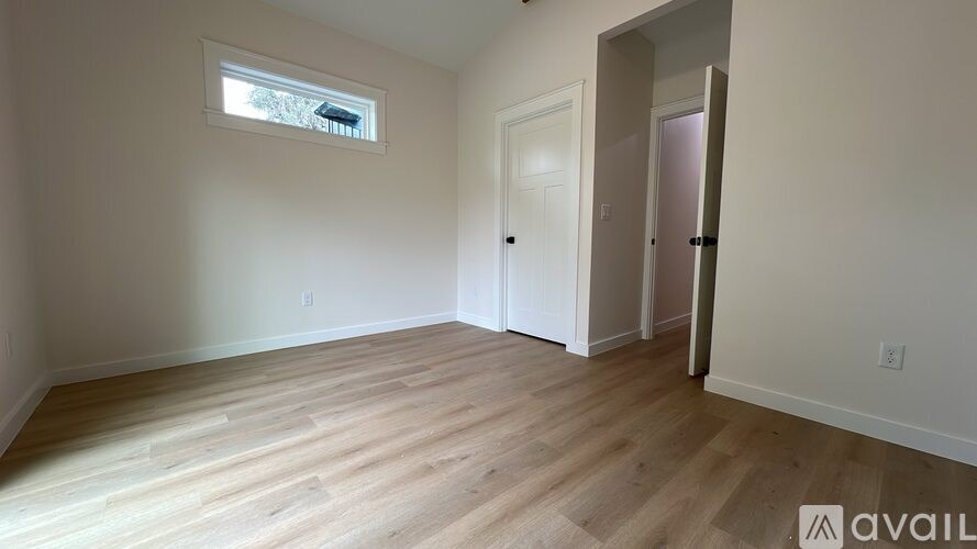 A room with wooden flooring and a window.