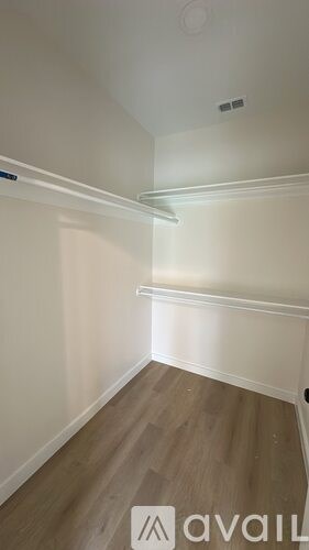 A room with wooden flooring and white walls.