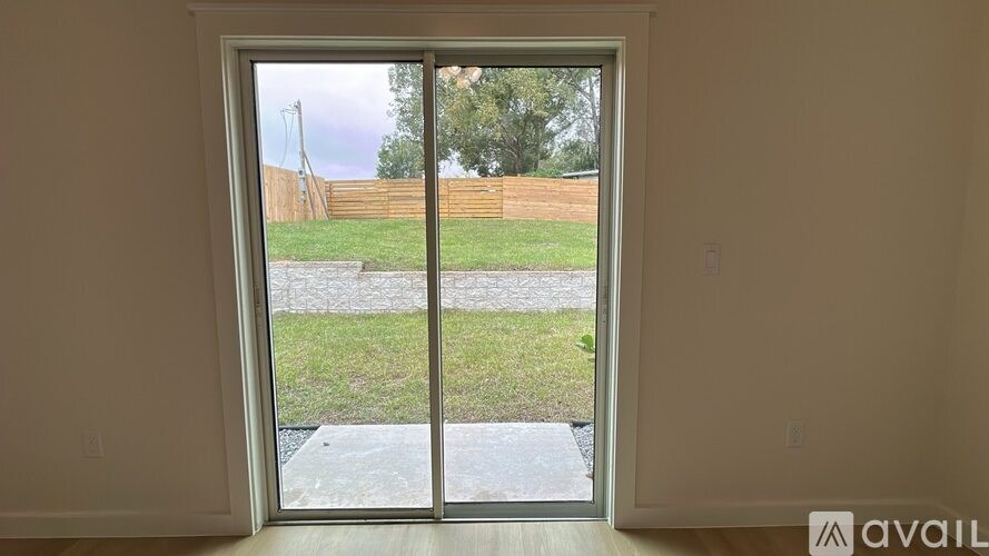 A window with a view of a backyard and a fence.