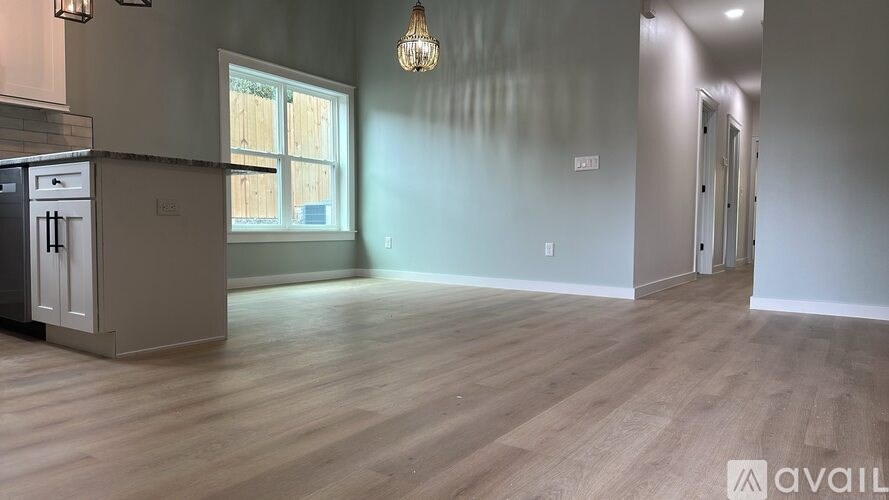A kitchen area with wooden flooring and a window.
