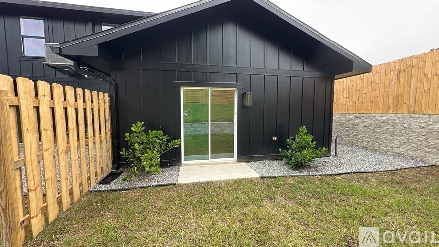A black house with a wooden fence in front.