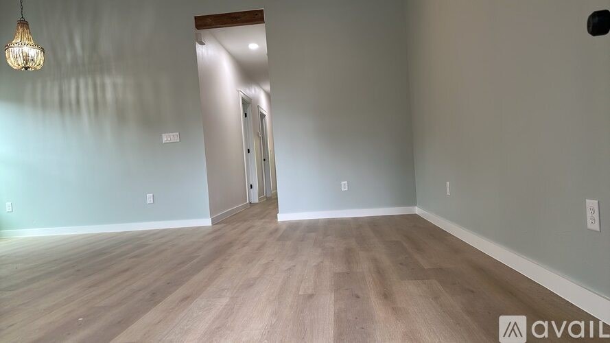 A room with wooden flooring and a light hanging from the ceiling.