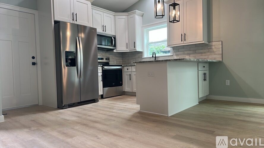 A kitchen with a refrigerator, microwave, oven, and a countertop.