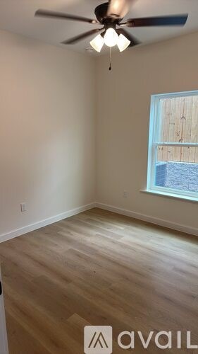 A room with a ceiling fan and a window.