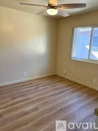 A room with a ceiling fan and a window.