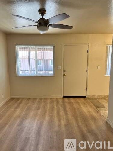 A room with a ceiling fan and a door.