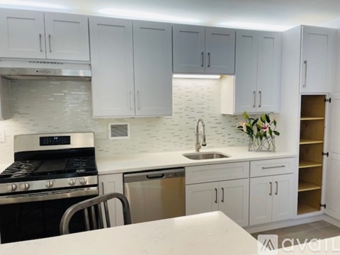 A kitchen with white cabinets and a black stove top oven.