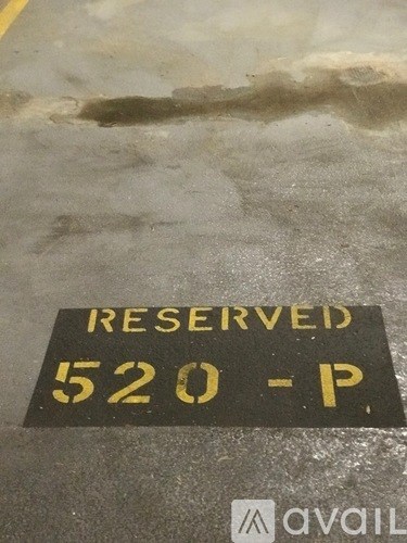 A parking sign that says "RESERVED 520-P" is on a dirty surface.