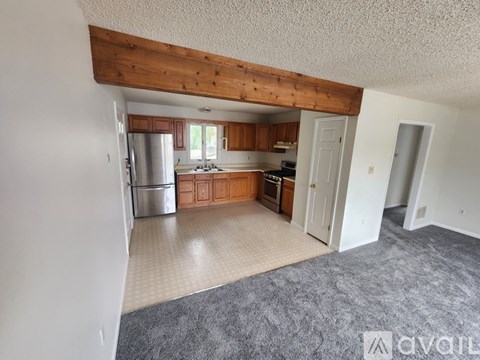 A kitchen with wooden cabinets and a refrigerator.