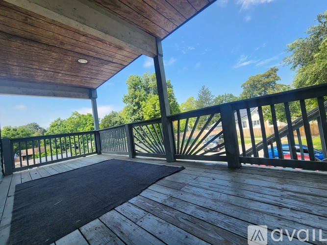 A wooden deck with a mat on it and a railing.