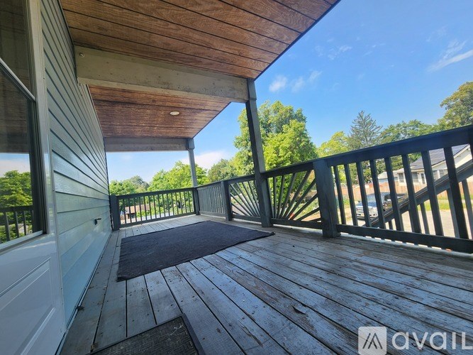 A wooden deck with a mat in the middle and a railing on the right side.