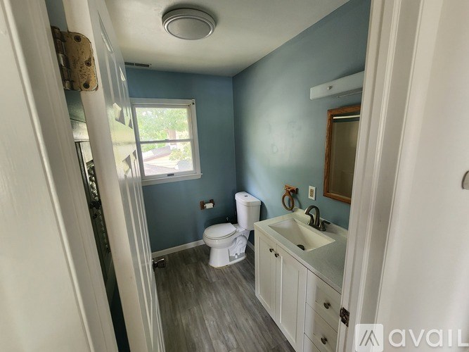 A bathroom with blue walls and a white toilet.