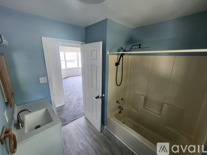 A bathroom with blue walls and a white door.