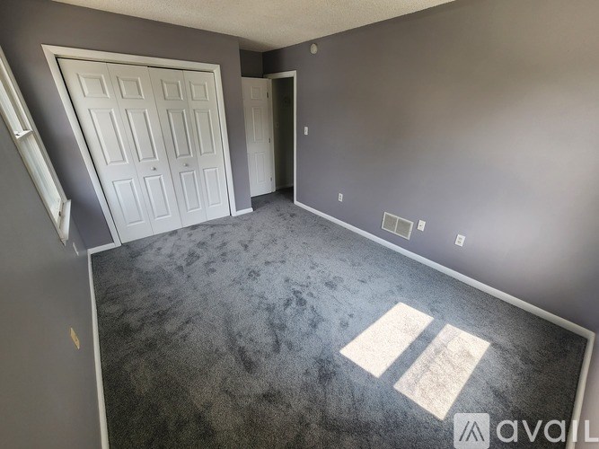 A room with a carpeted floor and a white door.