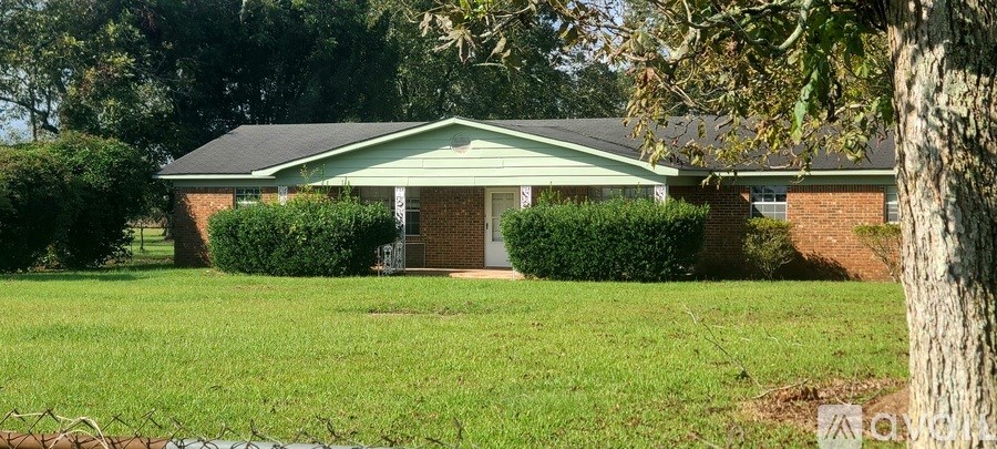 A house with a green lawn and a tree in front.