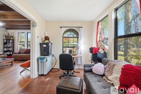 A living room with a grey couch and a black chair.