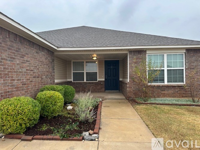A house with a front yard and a black door.