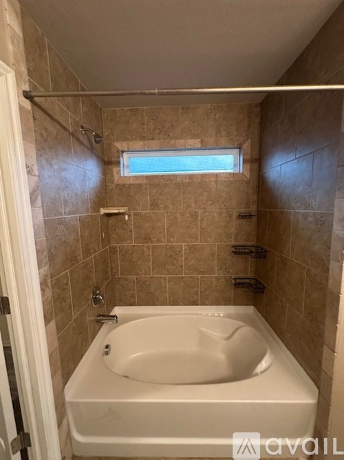 A bathroom with a tub and a window.