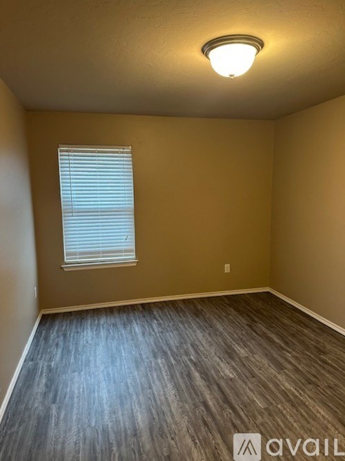 A room with a window and wooden flooring.