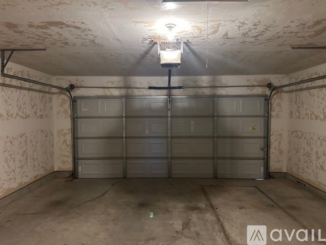 A garage with a closed door and a light on the ceiling.