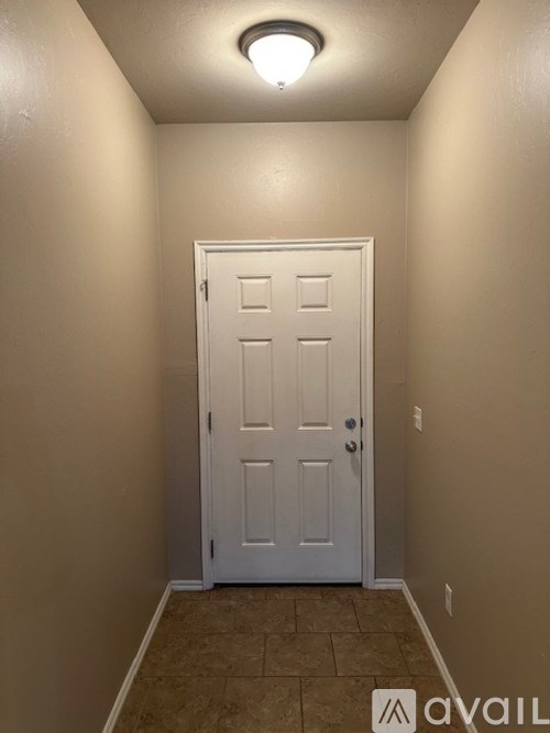 A white door is in the middle of a hallway.