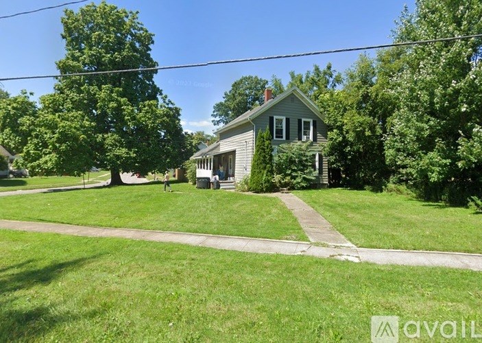 A house with a green lawn in front of it.