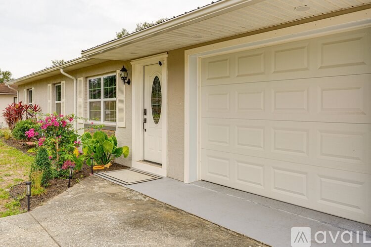 A white garage door is on the right side of a house.