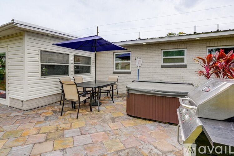 A patio with a table and chairs and a hot tub.