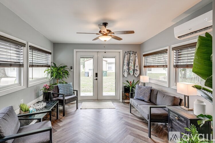 A living room with a ceiling fan and sliding glass doors.