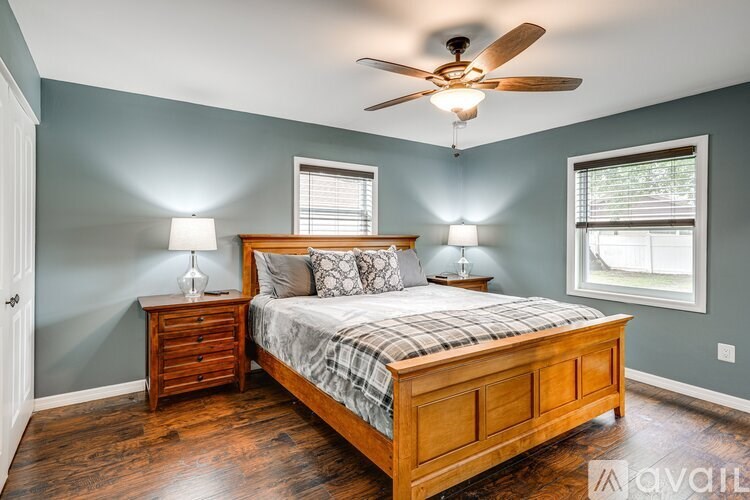 A bedroom with a bed, nightstands, and a ceiling fan.