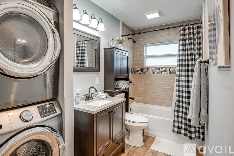 A modern bathroom with a washer and dryer built in.