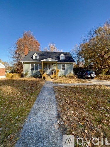 A house with a porch and a car parked in front.