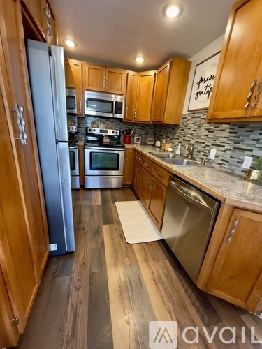 A kitchen with wooden cabinets and a stone backsplash.